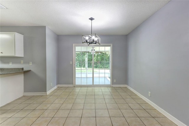 30 Bridgewater Way, Brunswick, GA 31525 - unfurnished dining area featuring a chandelier, a textured ceiling, light tile patterned floors, and baseboards
