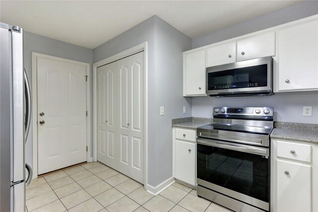 30 Bridgewater Way, Brunswick, GA 31525 - kitchen featuring appliances with stainless steel finishes, light tile patterned floors, white cabinets, light countertops, and baseboards