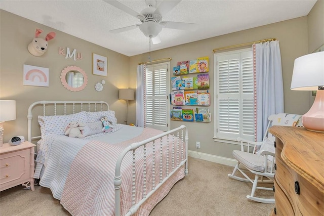 bedroom with baseboards, light carpet, a textured ceiling, and ceiling fan