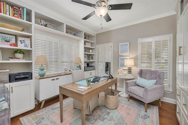 home office with baseboards, dark wood-type flooring, ornamental molding, and a ceiling fan