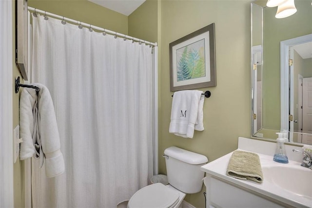 bathroom featuring vanity, curtained shower, and toilet