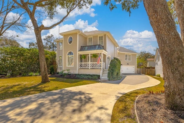 view of front facade with a front lawn, fence, covered porch, a garage, and driveway