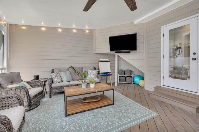 wooden deck with an outdoor living space and a ceiling fan