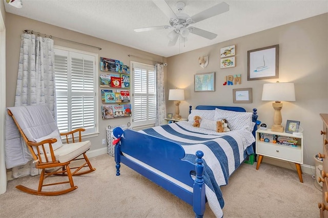 carpeted bedroom featuring a textured ceiling, a ceiling fan, and baseboards