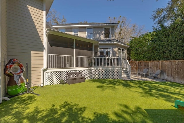 rear view of property featuring fence, a lawn, and a sunroom