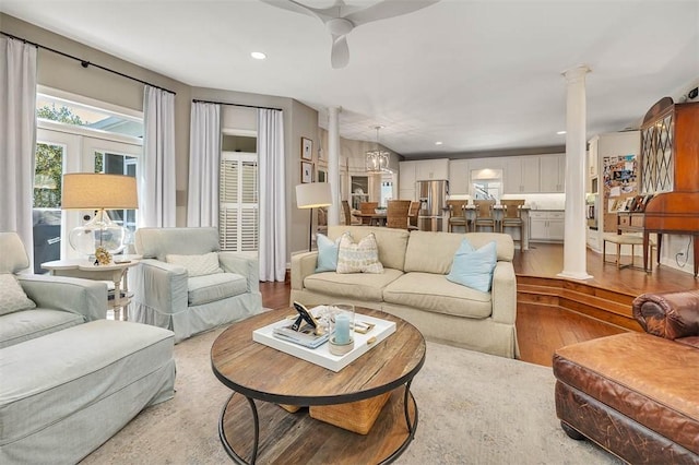 living area with recessed lighting, wood finished floors, and ornate columns