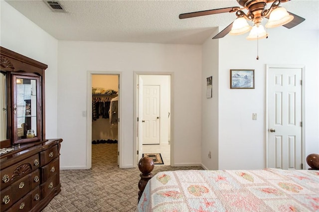 5604 Woodstone Dr, Blackshear, GA 31516 - carpeted bedroom featuring a textured ceiling, a closet, visible vents, a walk in closet, and baseboards