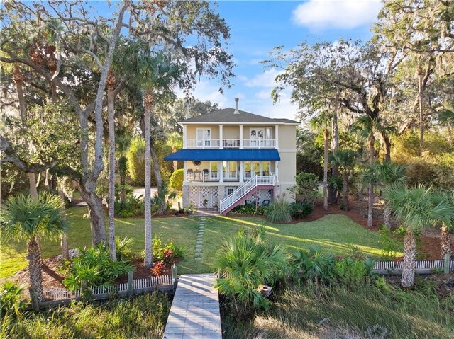 back of house with a porch, a yard, and a balcony