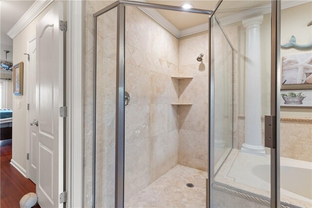 bathroom with hardwood / wood-style flooring, ornamental molding, shower with separate bathtub, and decorative columns