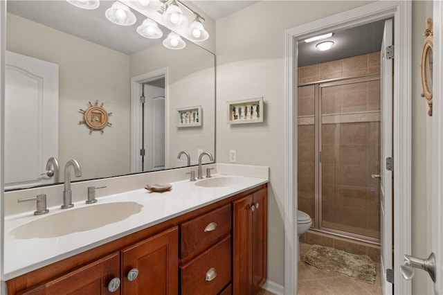 bathroom featuring tile patterned floors, vanity, toilet, and a shower with shower door