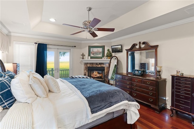 bedroom featuring ceiling fan, dark wood-type flooring, a raised ceiling, crown molding, and access to outside