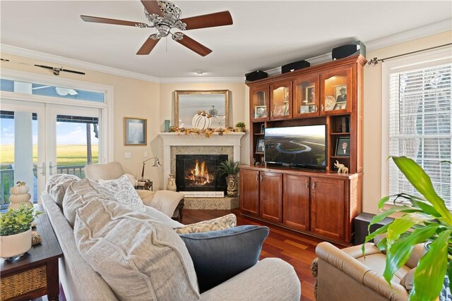 living room with ceiling fan, dark hardwood / wood-style flooring, a high end fireplace, and ornamental molding