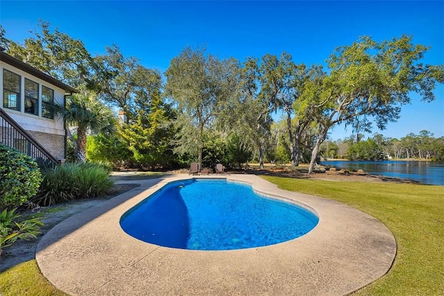 view of swimming pool featuring a water view and a lawn