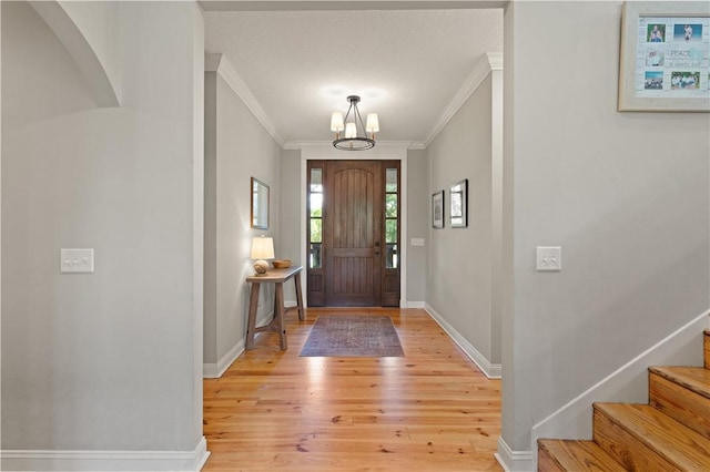 entryway featuring a chandelier, crown molding, and light hardwood / wood-style flooring