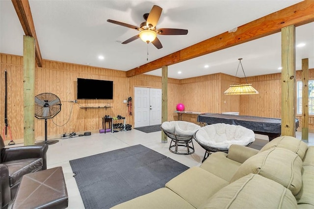 living room with beamed ceiling, ceiling fan, and wooden walls