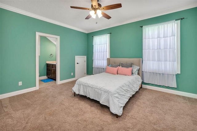 carpeted bedroom with connected bathroom, ceiling fan, and crown molding