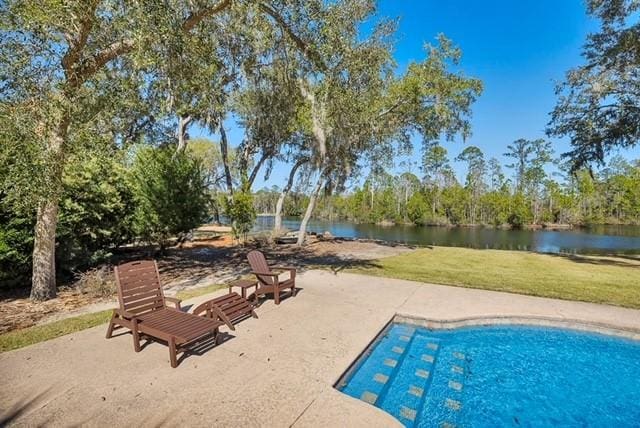 view of pool featuring a patio area, a yard, and a water view