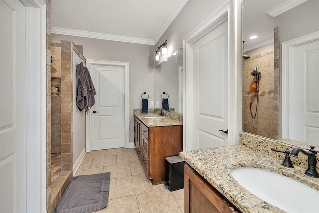 bathroom featuring tile patterned flooring, a tile shower, vanity, and crown molding