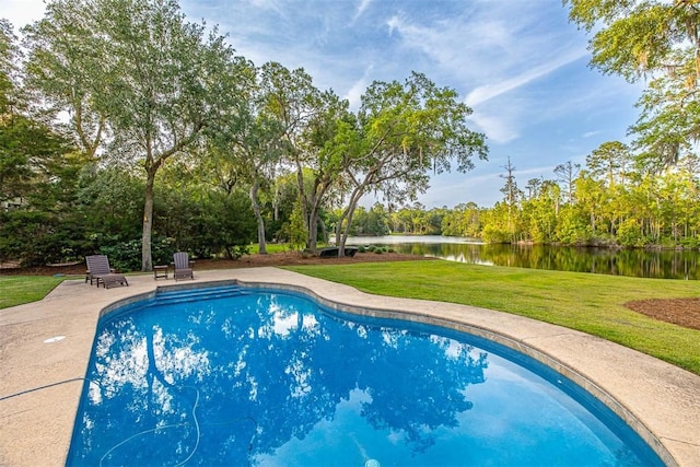 view of pool with a lawn, a patio area, and a water view