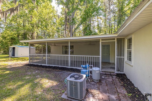 exterior space featuring central air condition unit, a porch, and a storage shed