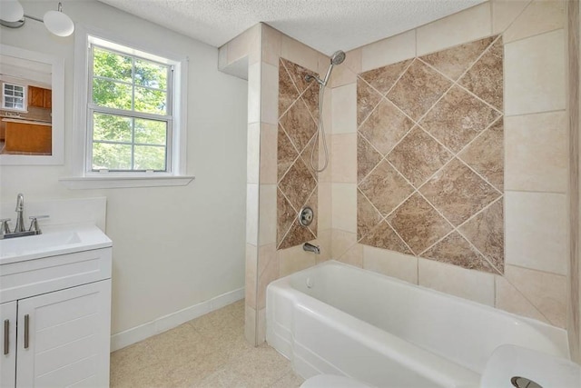 bathroom featuring a textured ceiling, vanity, and tiled shower / bath combo