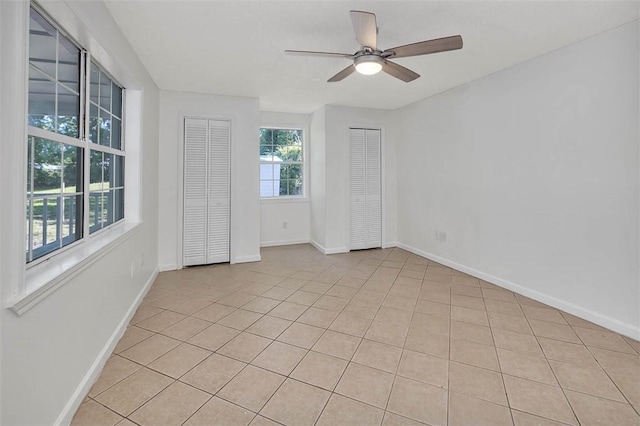 unfurnished room with ceiling fan and light tile patterned flooring