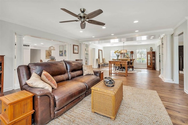 living room featuring ceiling fan, decorative columns, crown molding, and light hardwood / wood-style flooring