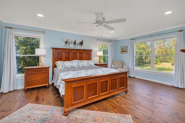 bedroom with dark hardwood / wood-style floors, ceiling fan, and crown molding