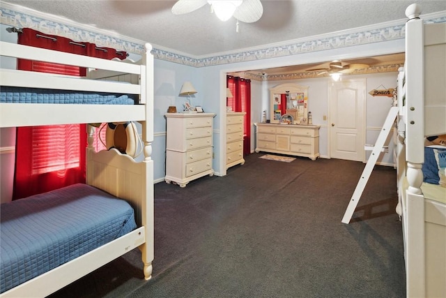 bedroom with ceiling fan, dark carpet, ornamental molding, and a textured ceiling