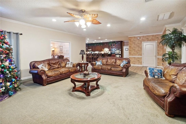 living room with ceiling fan, crown molding, carpet floors, and a textured ceiling