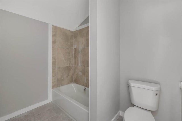 bathroom featuring toilet, tile patterned floors, bathing tub / shower combination, and lofted ceiling