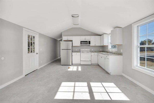 kitchen with vaulted ceiling, white cabinetry, stainless steel refrigerator, white electric range, and sink