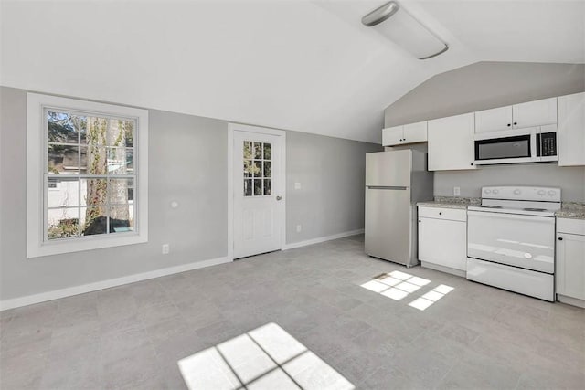 kitchen with lofted ceiling, white appliances, white cabinetry, and light stone counters