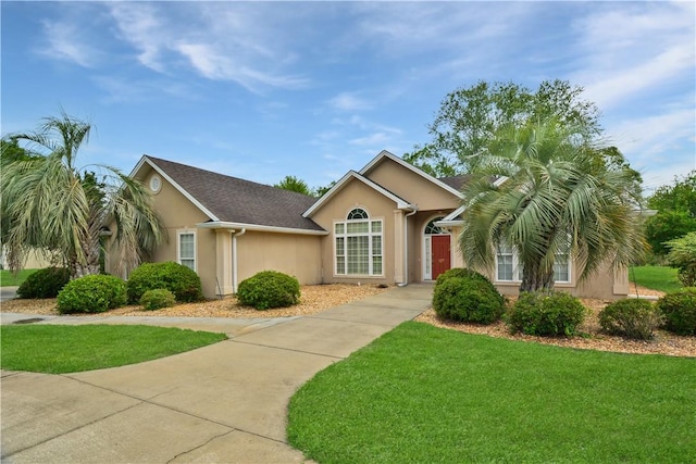 ranch-style home with a front lawn and stucco siding