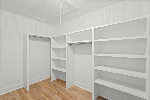 98 Atlantic Dr, Saint Simons Island, GA 31522 - walk in closet featuring attic access and wood finished floors