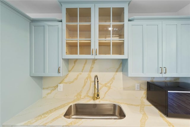 98 Atlantic Dr, Saint Simons Island, GA 31522 - kitchen with black microwave, glass insert cabinets, light stone countertops, and tasteful backsplash