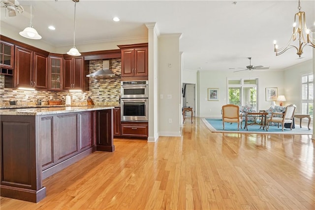 2306 Grand View Dr, Saint Simons Island, GA 31522 - kitchen featuring wall chimney exhaust hood, double oven, tasteful backsplash, a ceiling fan, and light wood-style flooring
