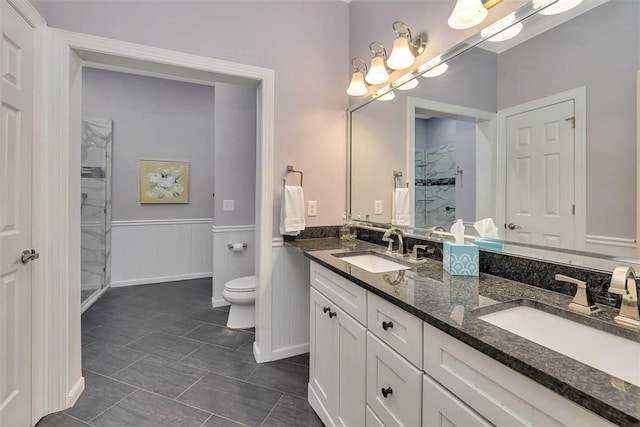 2306 Grand View Dr, Saint Simons Island, GA 31522 - bathroom with double vanity, a stall shower, toilet, and a wainscoted wall