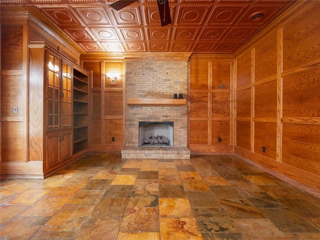 unfurnished living room with wooden walls and a brick fireplace