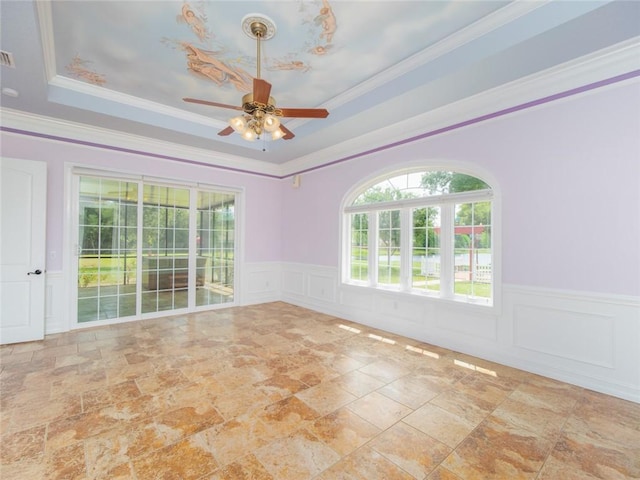 spare room with a tray ceiling, ceiling fan, and ornamental molding