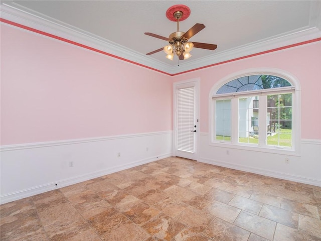 empty room featuring ceiling fan and crown molding