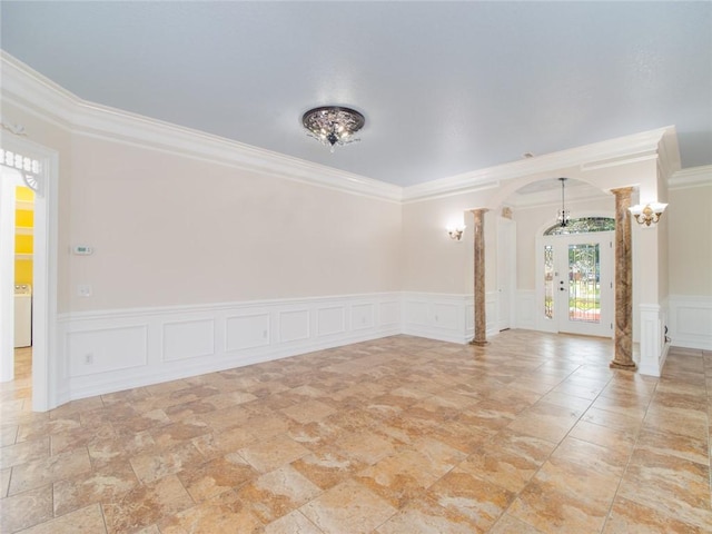 empty room featuring crown molding, washer / clothes dryer, and decorative columns