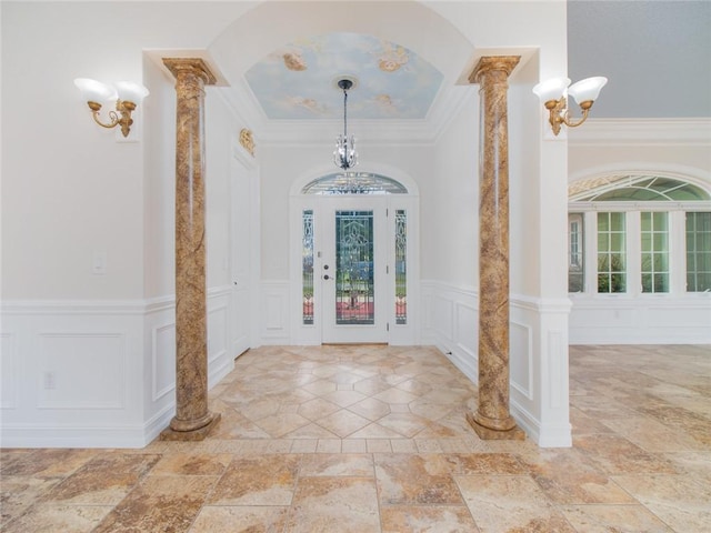 entryway featuring decorative columns and crown molding