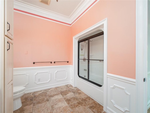 bathroom with toilet, combined bath / shower with glass door, and ornamental molding