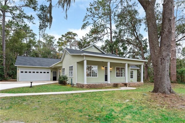 view of front facade featuring a front lawn, covered porch, and a garage