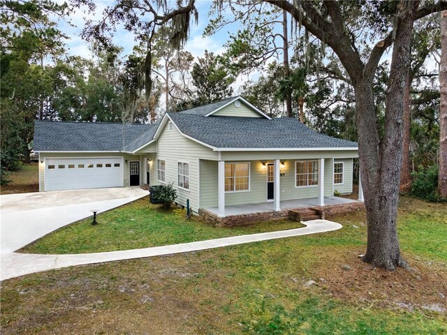 view of front facade with a front lawn, covered porch, and a garage