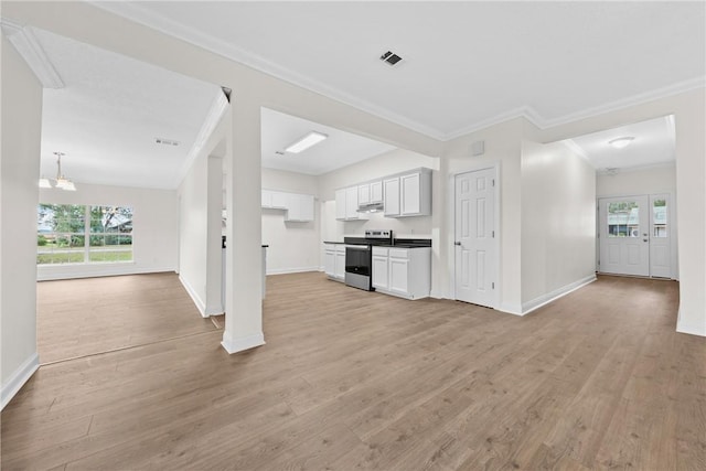 unfurnished living room featuring a notable chandelier, light hardwood / wood-style floors, and crown molding