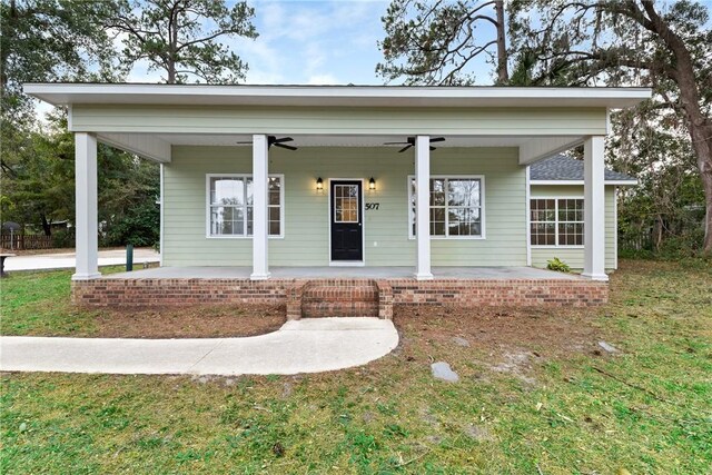 view of front of home with ceiling fan, covered porch, and a front yard