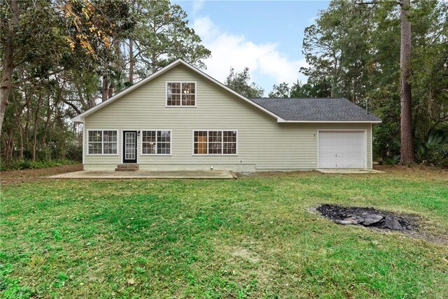 rear view of house with a lawn and a garage