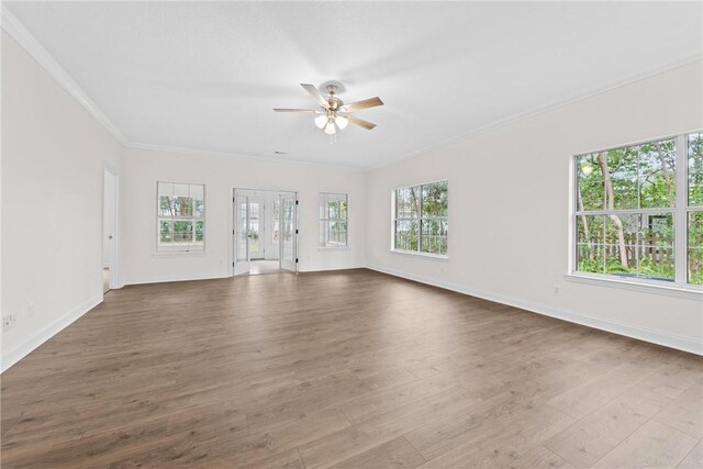 unfurnished living room featuring ceiling fan, light hardwood / wood-style floors, and ornamental molding